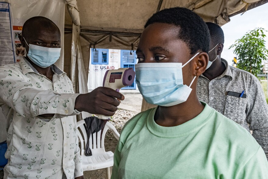 Photo of an official scanning a patient for ebola